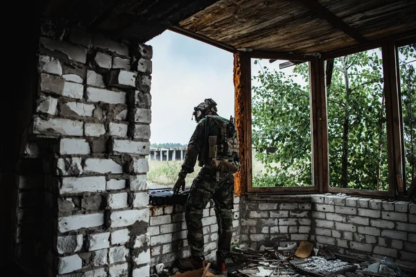 The soldier pulls a rifle out of the ammunition case and insert ammunition clip into assault rifle