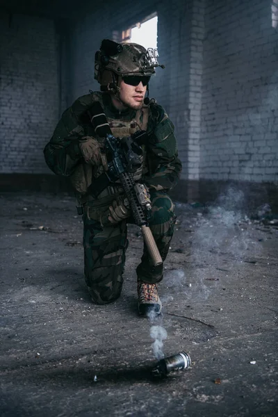 Military man during combat and smoke grenade on a ground. — Stock Photo, Image