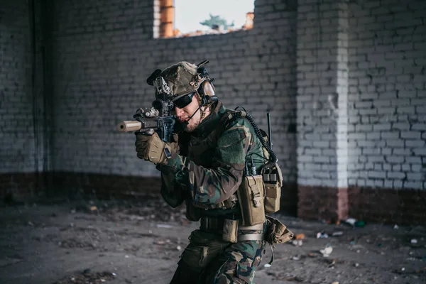 Soldaat in volle Amerikaanse MARSOC-uitrusting betreedt verlaten gebouw, gericht op verschillende hoeken met MK18 aanvalsgeweer — Stockfoto