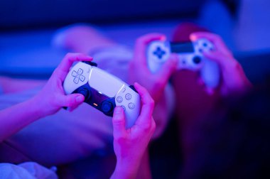 Yeni Sony Playstation 5 DualSense kablosuz kontrol cihazı kullanan bir kız. Bu kontrol, dinamik adaptif tetikleyiciler ve dahili mikrofon sunuyor. Moskova - 28 Kasım 2020.