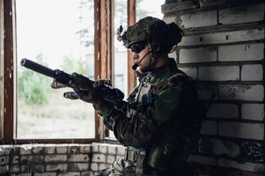 Dışarıda yağmur yağarken askeri bir operasyondan dinlenen düşünceli bir asker..