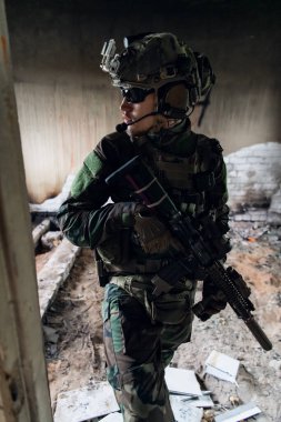 Ön cephede, elinde tüfekle beyaz bir asker var. Etrafı kolaçan ediyor..