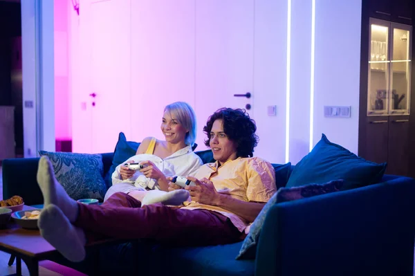 Happy young couple playing a video game sitting at home on a sofa during self isolation on quarantine. — Stock Photo, Image