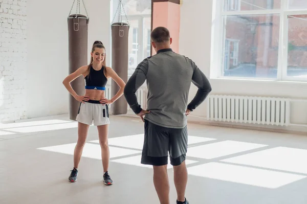 매력적 인 한 젊은 권투 선수가 자신의 여자 친구에게 권투 훈련 시설이 갖춰진 다락방에서 권투 기술을 가르치고 있다 — 스톡 사진