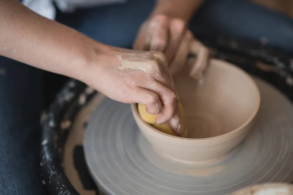 Potter faz o produto de argila com ferramentas de modelagem de cerâmica na roda de oleiros. — Fotografia de Stock