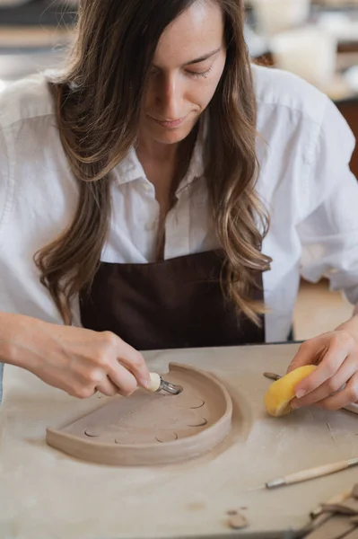 Gros plan d'un maître potier, outil spécial de découpe d'argile. Découpe d'artiste féminine avec un outil de boucle en bois — Photo