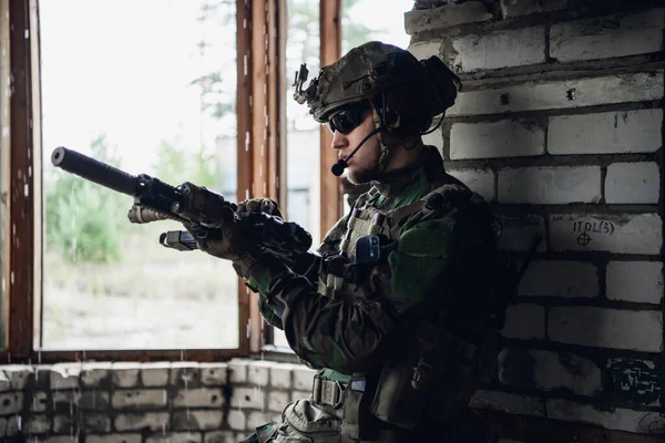 Un soldat réfléchi, qui se repose d'une opération militaire alors qu'il pleut dehors. — Photo