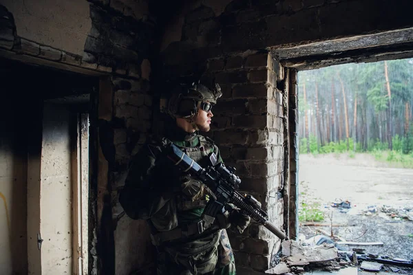 Vue de face gros plan du soldat caucasien avec un fusil monter la garde sécuriser le territoire en regardant autour. — Photo