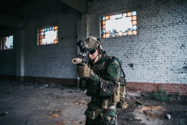 Specialstyrkor soldat går med siktat attackgevär i förstörd byggnad. — Stockfoto