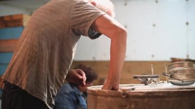 Arı yetiştiricisi bal çıkarmak için bal sökücüsünü bal peteğiyle dolduruyor..