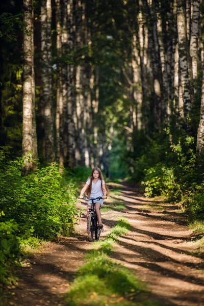 Children girl riding bicycle outdoor in forest smiling. — Stock Photo, Image