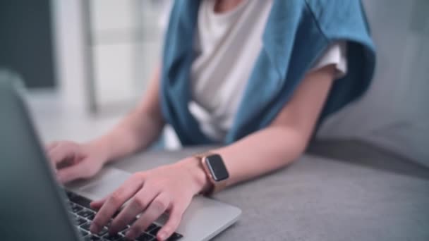 Ung affärskvinna bär smarta klockor skriva på laptop tangentbord och skriva. Karantän. isolering, socialt avståndstagande, frilansarbete från hemmakontoret, isolering. — Stockvideo