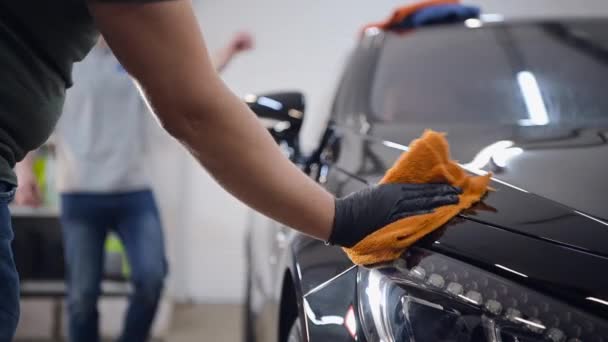 Dos especialistas secan el coche de la humedad, lavado de coches en el servicio de detalles. — Vídeos de Stock