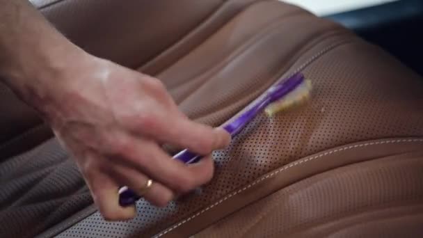 Usando escova para limpar e polir assentos de couro de poeira e sujeira. Limpeza automática profissional. — Vídeo de Stock