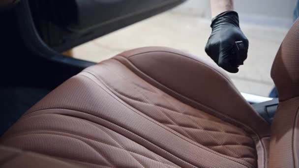 Мужчина чистильщик носить черные перчатки дезинфицировать автомобиль переднее сиденье с помощью спрея, дезинфицирующее средство стереть загрязненную поверхность, COVID19 коронавируса. — стоковое видео