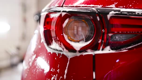 Підсвічування автомобіля вкрито білою піною для миття крупним планом — стокове відео