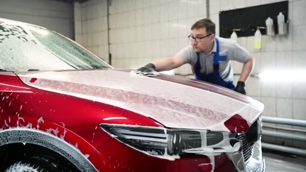 Lavado moderno con espuma y agua de alta presión de un coche rojo. — Vídeo de stock