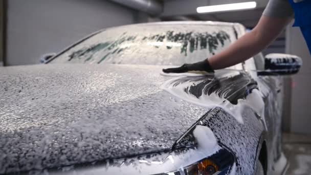Hombre trabajador en guante negro con esponja de espuma lavado de coches en el servicio de coche, lavado de coches — Vídeos de Stock