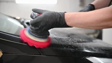 Araba temizleme - yavaş çekimde oto tamir atölyesinde orbital cilalayıcı ile eller.
