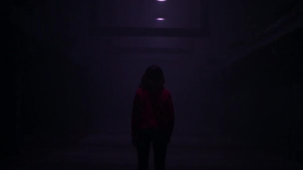 A woman experiences fear and panic while walking in a dark corridor. Horror maniac concept. — Stock Video