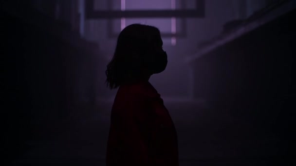 Mujer con máscara facial de pie en un túnel oscuro con luces rojas. Concepto de arte de depresión pandémica. Depresión causada por coronavirus, cuarentena, COVID 19. Salud humana. — Vídeos de Stock