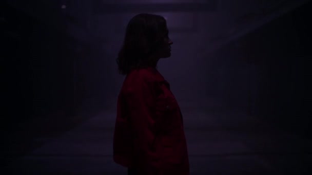 Жінка стоїть на самоті в темному тунелі. Депресивна дівчина — стокове відео