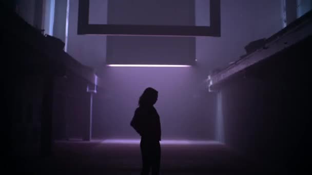 Žena v červené bundě pomalu tančí v tmavém tunelu se světelnými efekty. Taneční záběry pro hudební video. — Stock video