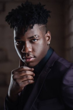 Kameraya bakan yakışıklı, şık, Afro-Amerikan bir adamın yakın portresi..