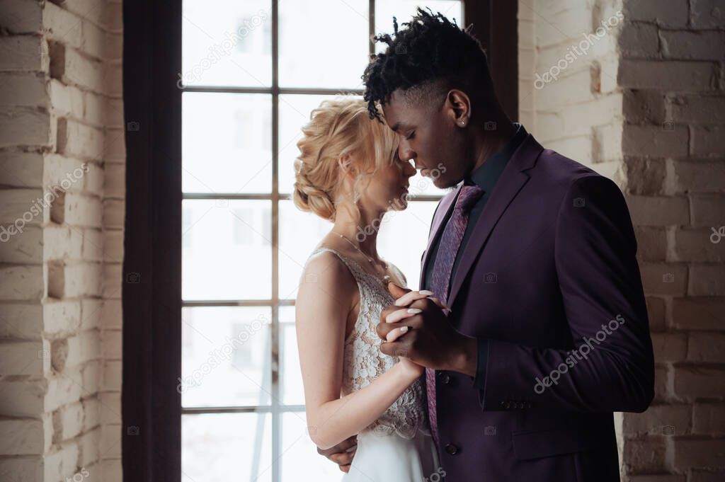 Interracial tender wedding couple. Young african american man and caucasian woman rehearse wedding dance. Mixed-race groom and bride.