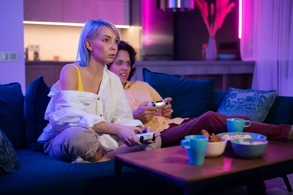 Junge fröhliche kaukasische Eheleute spielen zu Hause Videospiele gegeneinander und genießen die Freizeit — Stockfoto