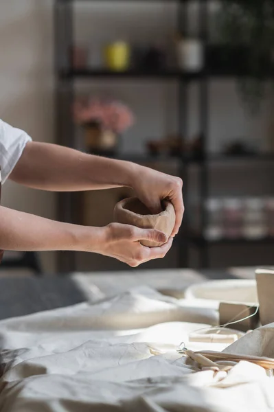 The potters woman hands are shaping a cup from a clay. The process of creating pottery. The master ceramist works in his studio. Close-up, only hands. Crockery from clay own hand — Stock Photo, Image