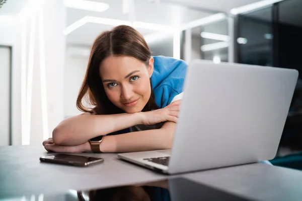 Retrato de feliz mujer caucásica exitosa en ropa informal mirando y sonriendo a la cámara. Atractiva gestora femenina en aislamiento personal después de un duro día de trabajo remoto — Foto de Stock