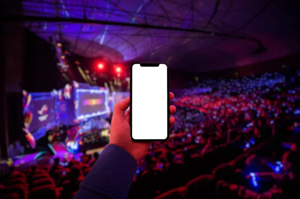 Чоловік використовує цифровий додаток на мобільному смартфоні на заході esport на великій арені. Порожній екран з пробілом для копіювання . — стокове фото
