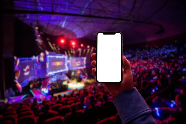 Χρήση ψηφιακής εφαρμογής στο κινητό smart phone στο esport event στη μεγάλη αρένα. Κενή οθόνη με χώρο αντιγραφής. — Φωτογραφία Αρχείου