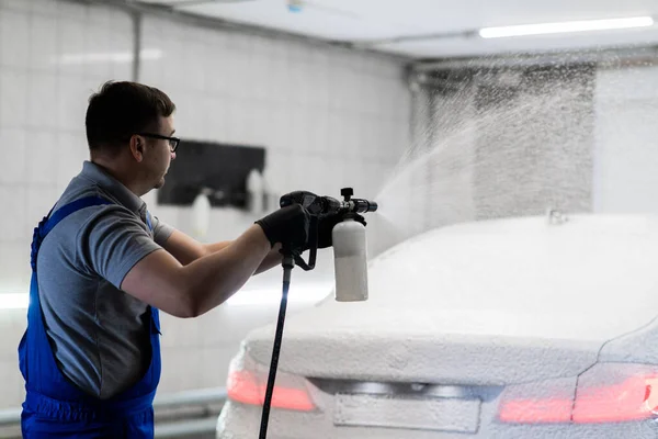 Worker covering automobile with foam at car wash. — Stock Photo, Image