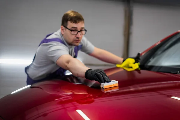 Hombre trabajador del estudio de detalles del coche aplicando recubrimiento de cerámica en la pintura del coche con aplicador de esponja — Foto de Stock