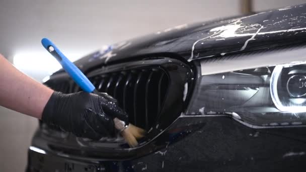 Επαγγελματική φροντίδα αυτοκινήτου μαύρο αυτοκίνητο εξωτερικό ψυγείο πλέγμα με βούρτσα. — Αρχείο Βίντεο