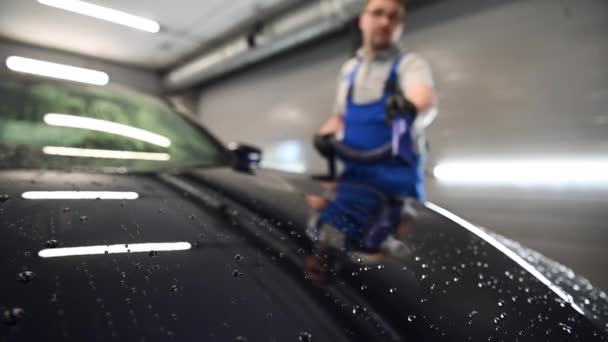 Slow motion close-up blazen van water uit vers gewassen zwarte auto met lucht. Auto wassen en detaillering service. — Stockvideo