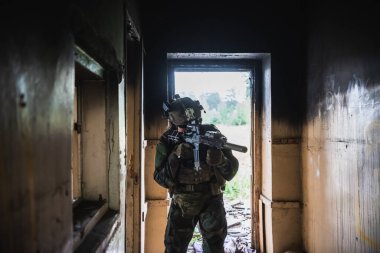Terk edilmiş binaya giren tam donanımlı Amerikan askeri, MK18 saldırı tüfeğiyle farklı açıları hedefliyor.