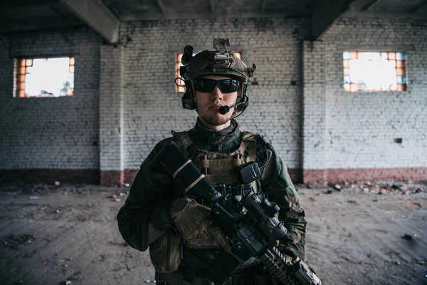 Militar con rifle de asalto de pie dentro del edificio, está listo para el combate —  Fotos de Stock
