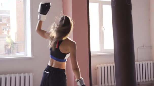 Krásná Kickboxing žena unavená z tréninku s boxovací pytel ve fitness studiu divoká síla fit tělo zpomalit kickboxer — Stock video