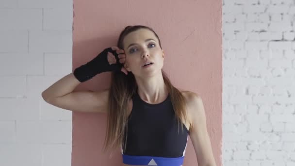 Beautiful Kickboxing woman tired from training with punching bag in fitness studio fierce strength fit body slow motion kickboxer — Stock Video