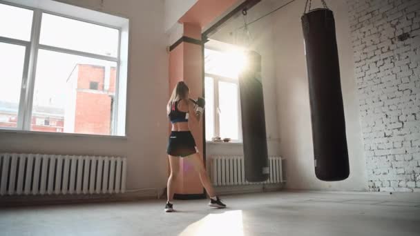 Žena sportovec box boxovací pytel v městské průmyslové tělocvičny — Stock video