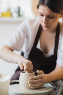 Çömlek atölyesinde esrar yapan çömlekçiye yakın çekim. Kil nemlendirmek için sünger ve su kullanılıyor..