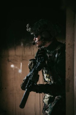 Tam teşekküllü Amerikan askeri MARSOC terk edilmiş binada saldırı tüfeğiyle koşuyor. Askeri çatışma..