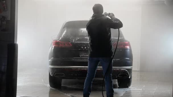 Werknemer schoonmaken van auto met hoge druk water jet bij car wash. — Stockvideo