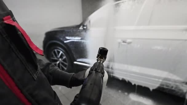 Processus de lavage de voiture au point de vue de la première personne. Le détergent moussant couvre le côté de la voiture, nettoie-le de la saleté et de la poussière. — Video