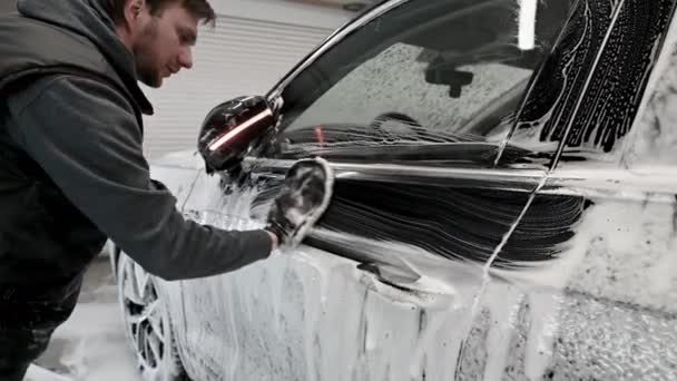 Manlig arbetare i svart handske med skumsvamp tvättbil vid bilservice, biltvätt — Stockvideo