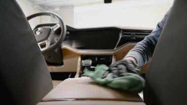 Araba temizliği. Paçavralı eller arabanın içini temizler..