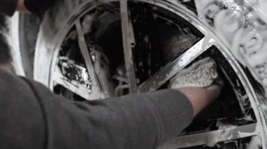 Köpük süngerli erkek el araba tekerleği yıkıyor. Erkek el temizleme araba tekerleği.